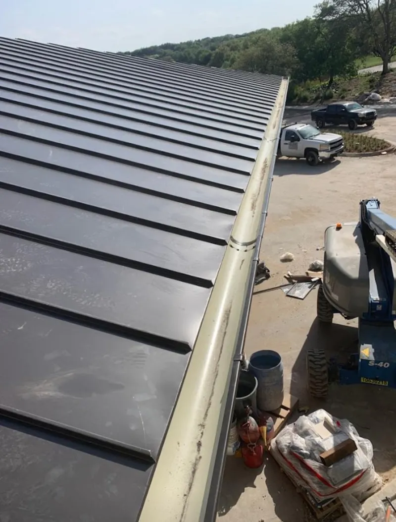 Standing seam panel and gutter detail on a metal roofing jobsite in Elkins
